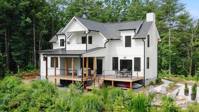 rear view of property featuring a balcony and a deck