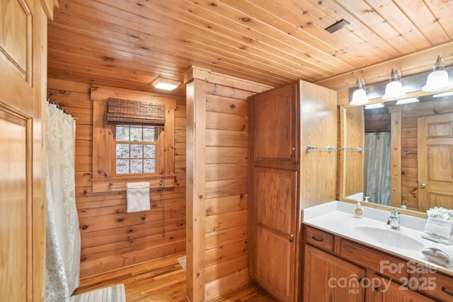 bathroom featuring hardwood / wood-style flooring, vanity, wooden walls, and wood ceiling