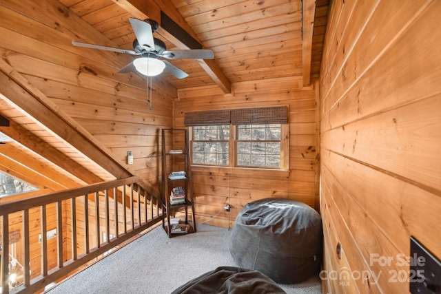 unfurnished bedroom with beamed ceiling, carpet flooring, wood ceiling, and wood walls