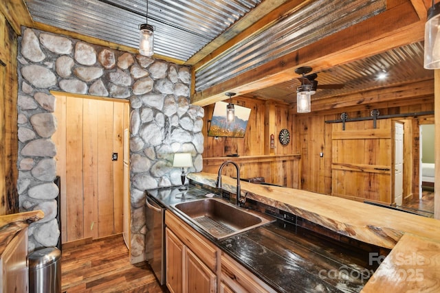 kitchen featuring dishwasher, sink, wooden counters, and decorative light fixtures