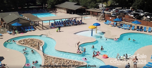 view of swimming pool featuring a water slide and a patio area