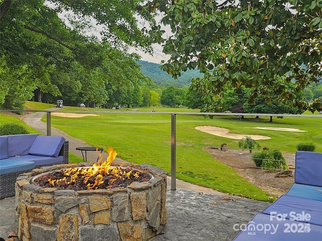 view of home's community with an outdoor fire pit and a yard