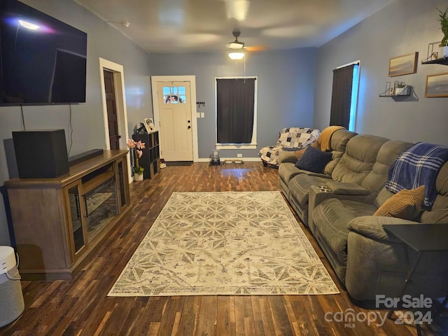 living room featuring ceiling fan and dark hardwood / wood-style flooring