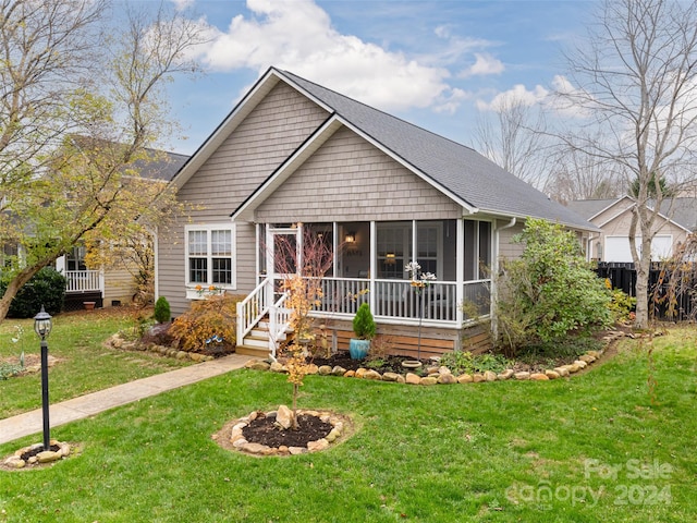 view of front of property featuring a sunroom and a front lawn