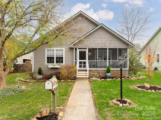 view of front facade featuring a sunroom and a front lawn