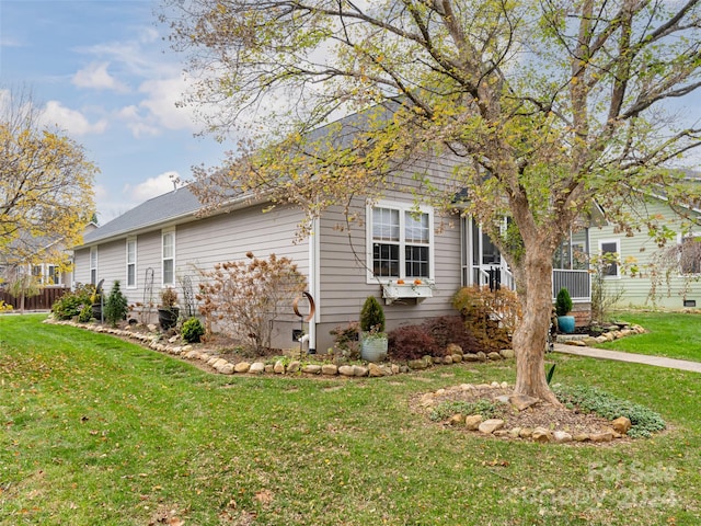 view of side of home with a lawn