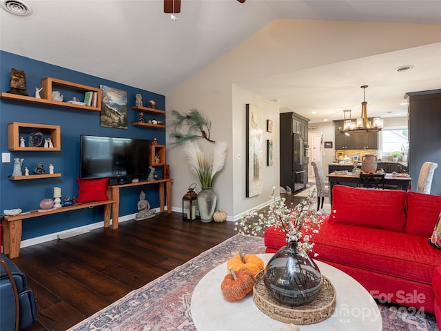 living room featuring dark hardwood / wood-style flooring, lofted ceiling, and an inviting chandelier