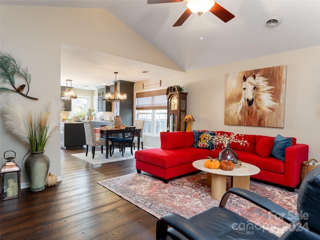 living room with dark hardwood / wood-style flooring, ceiling fan with notable chandelier, and vaulted ceiling