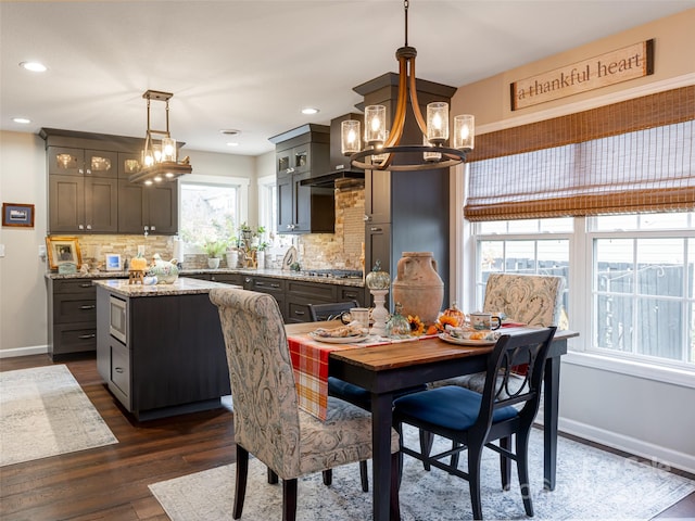 dining area with dark hardwood / wood-style floors and a notable chandelier