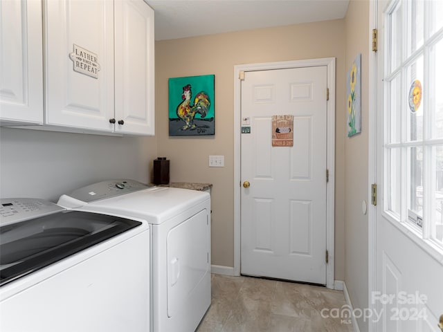 washroom featuring washer and dryer and cabinets