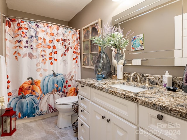 bathroom with vanity, curtained shower, and toilet