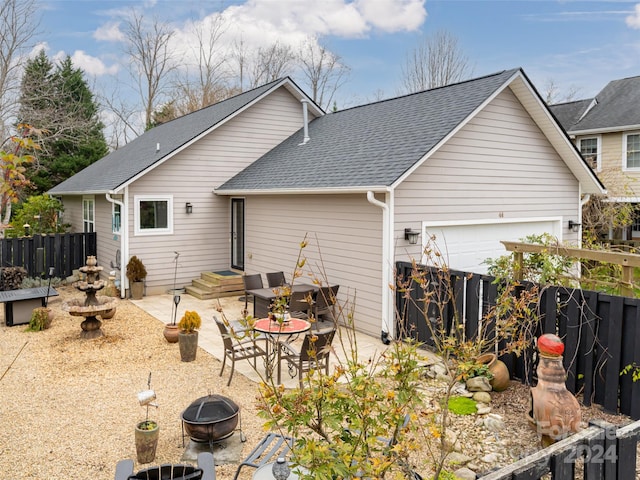 rear view of property featuring a patio and an outdoor fire pit