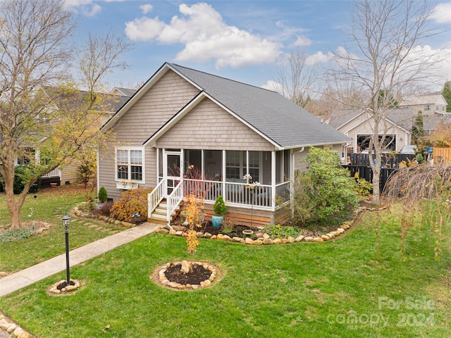 view of front of house featuring a sunroom and a front yard