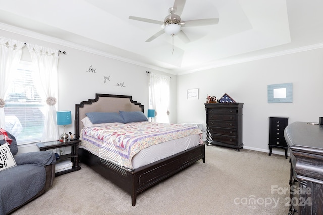 carpeted bedroom featuring a tray ceiling, multiple windows, ceiling fan, and crown molding