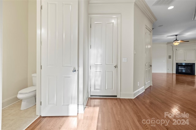 corridor with light wood-type flooring and ornamental molding