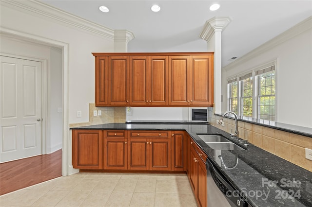 kitchen with dishwasher, sink, dark stone counters, light tile patterned floors, and ornamental molding