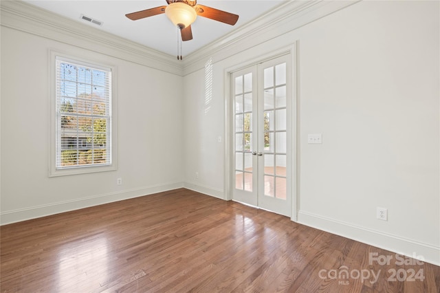 empty room featuring hardwood / wood-style floors, ceiling fan, ornamental molding, and french doors