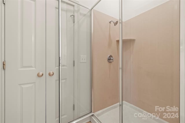 bathroom featuring a shower with shower door