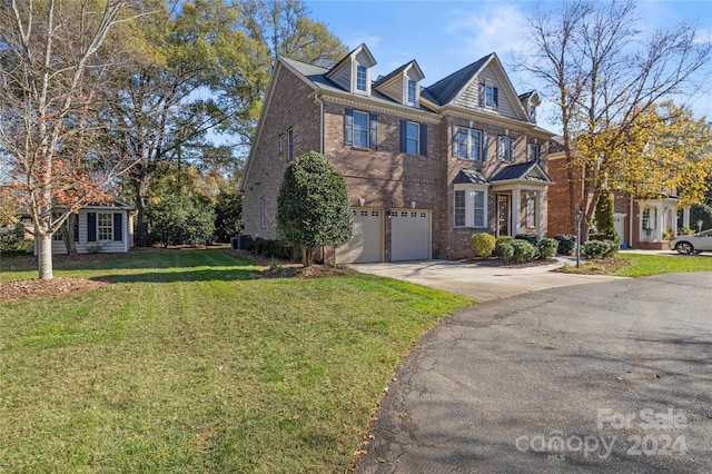 view of front of house featuring a garage, a front yard, and central AC