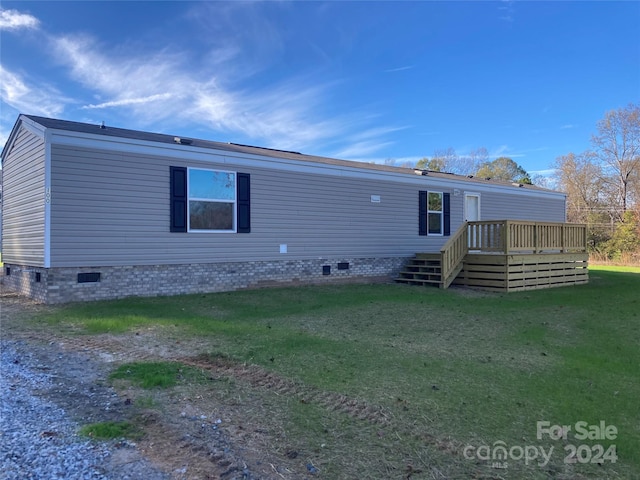 back of house with a lawn and a wooden deck