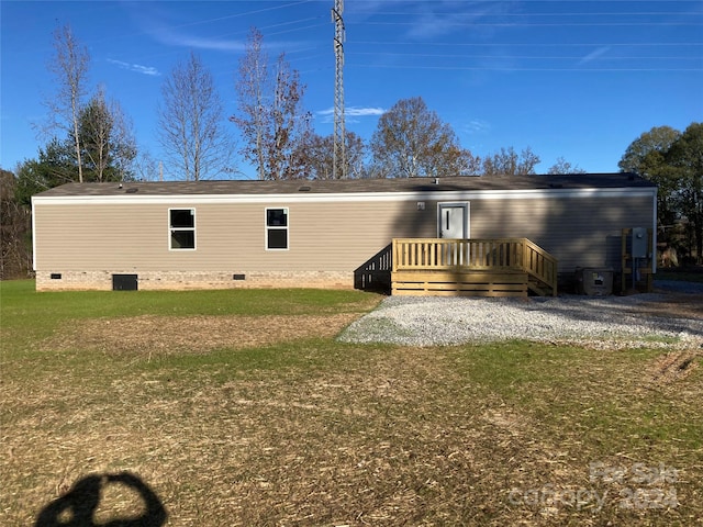 back of house with cooling unit, a deck, and a yard