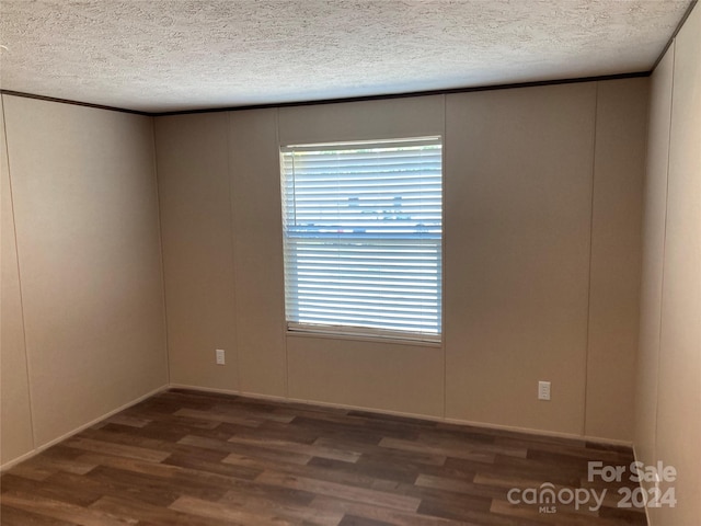 unfurnished room featuring dark hardwood / wood-style floors and a textured ceiling