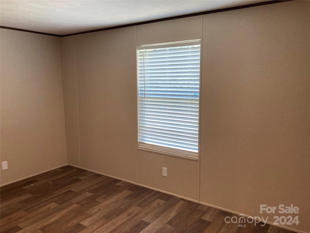 spare room with dark hardwood / wood-style flooring and a textured ceiling