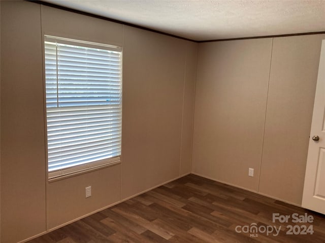 unfurnished room featuring a textured ceiling and dark wood-type flooring