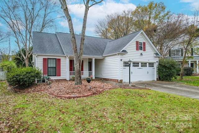 view of front of house with covered porch, a front yard, and a garage