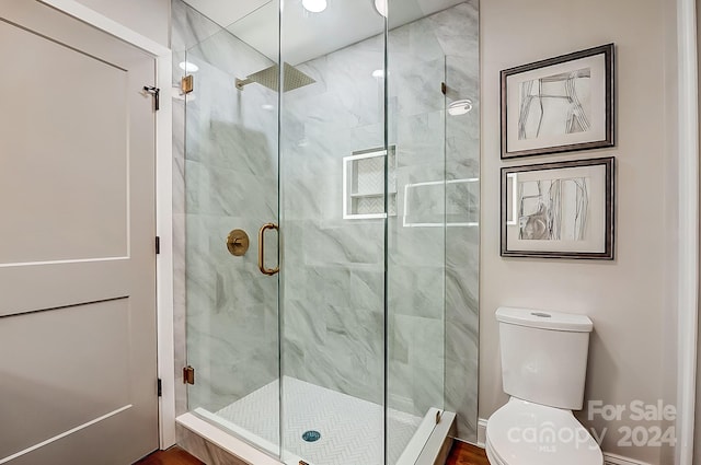 bathroom featuring toilet and walk in shower