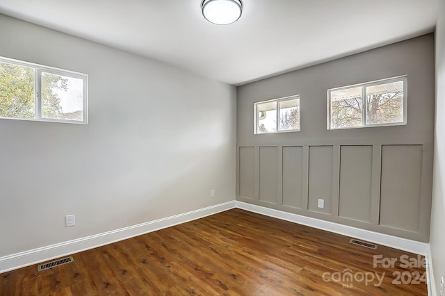 spare room with plenty of natural light and dark wood-type flooring