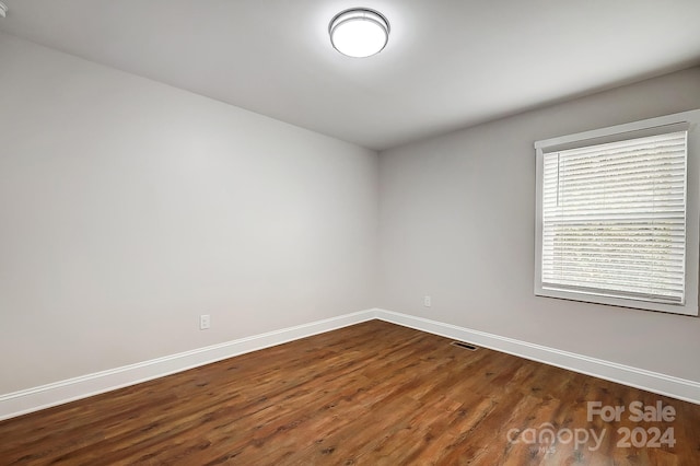 unfurnished room with dark hardwood / wood-style floors