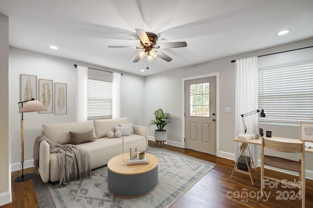 living room with ceiling fan and dark wood-type flooring