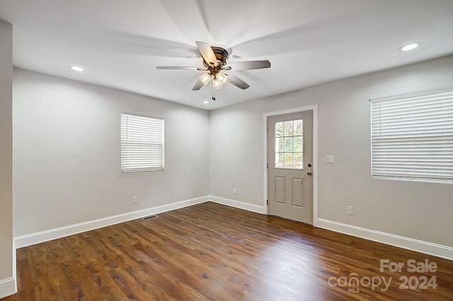 unfurnished room with ceiling fan and dark wood-type flooring