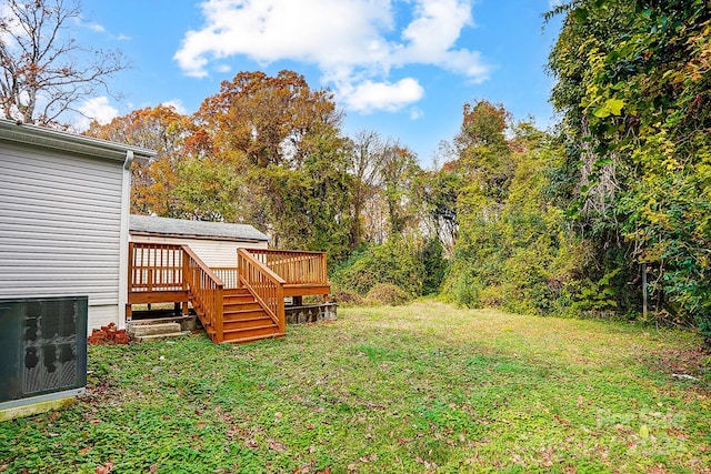 view of yard with central AC and a deck