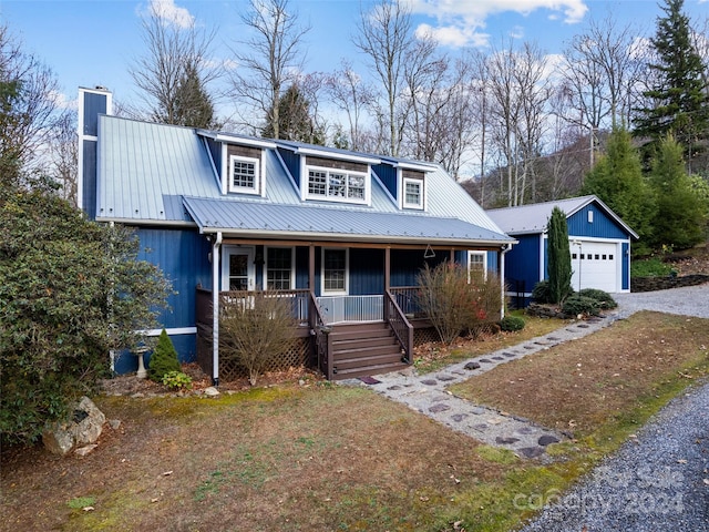 view of front of property featuring covered porch, an outdoor structure, and a garage