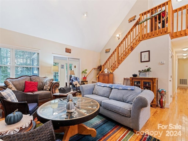 living room featuring light hardwood / wood-style floors and high vaulted ceiling