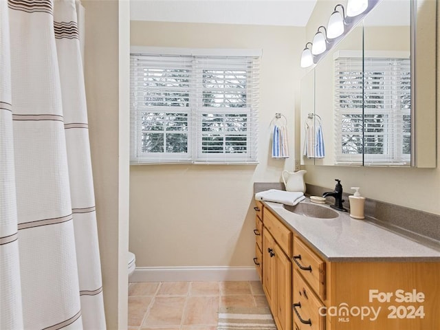 bathroom featuring tile patterned floors, vanity, and toilet