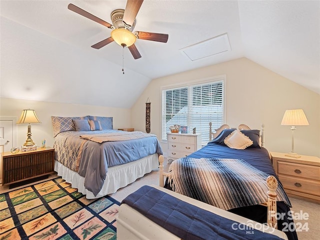 carpeted bedroom with ceiling fan and vaulted ceiling