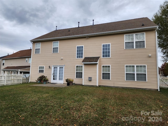 rear view of property featuring a patio area and a lawn