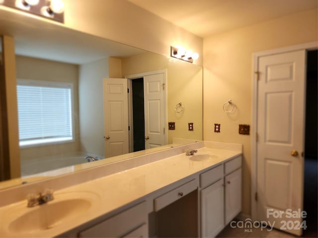 bathroom featuring a washtub and vanity