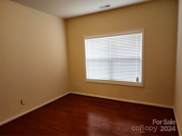 unfurnished room with dark hardwood / wood-style flooring