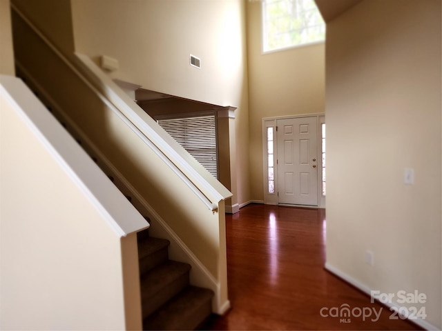 entryway with dark hardwood / wood-style floors and a high ceiling