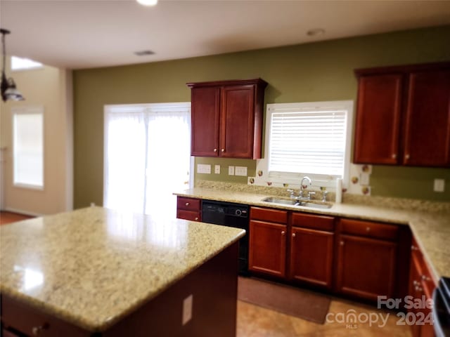 kitchen featuring black dishwasher, a center island, light stone countertops, and sink