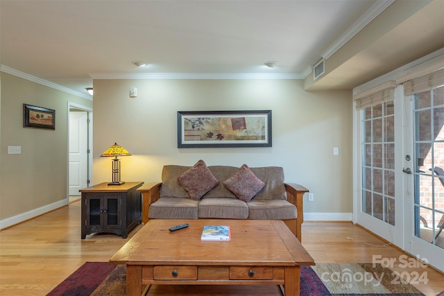 living room featuring french doors, crown molding, and light hardwood / wood-style flooring