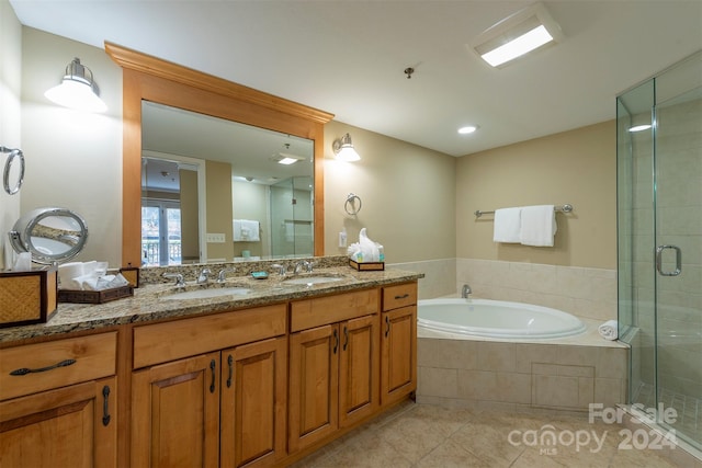 bathroom featuring plus walk in shower, vanity, and tile patterned floors