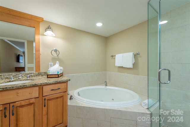 bathroom featuring vanity and independent shower and bath