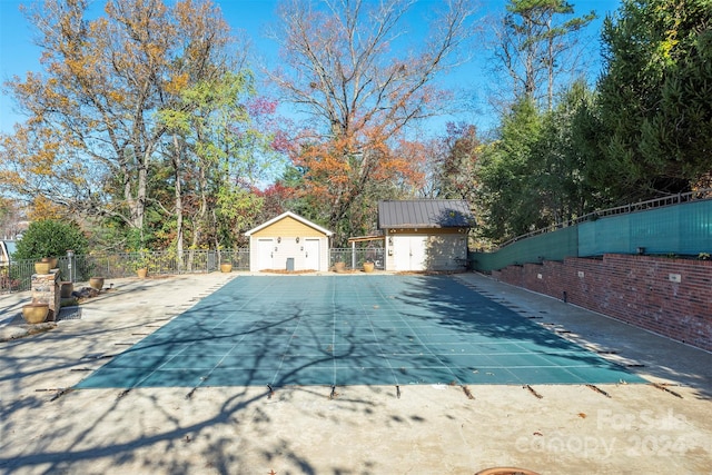 view of pool with a patio area and a shed