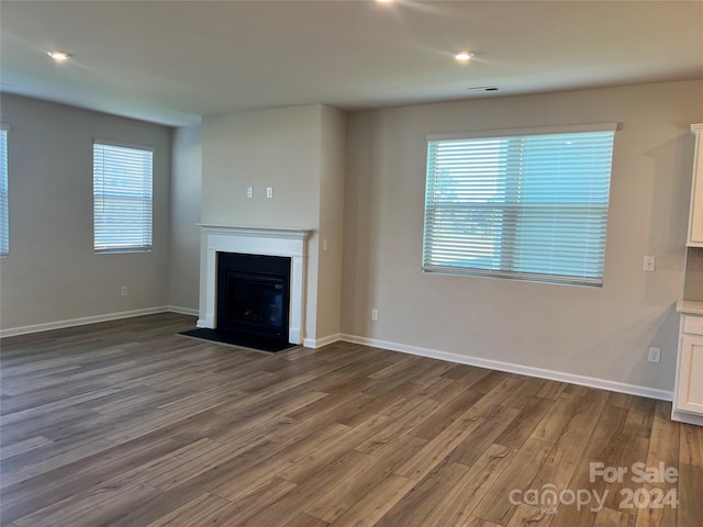 unfurnished living room with a healthy amount of sunlight and wood-type flooring