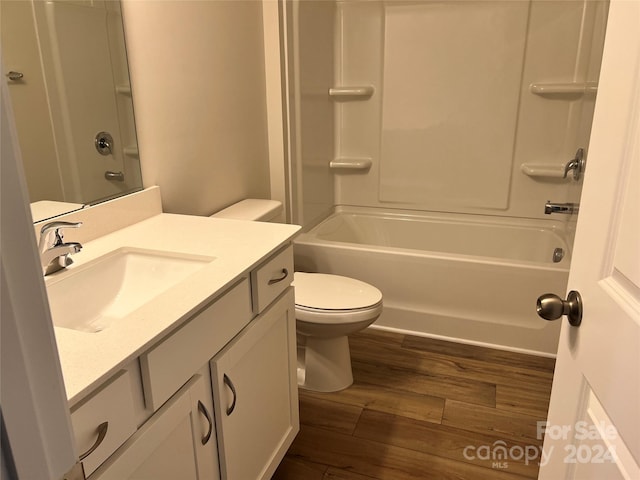 full bathroom with shower / bathing tub combination, vanity, hardwood / wood-style flooring, and toilet